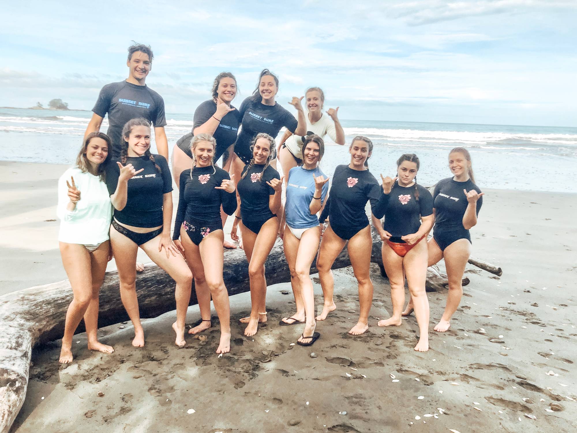 2019 GVSU HTM Costa Rica students wearing wetsuits on the beach before surfing lessons